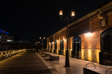 Fototapeta na wymiar 日本のライトアップされた神戸ハーバーランド煉瓦倉庫と木製のハーバーウォーク