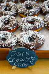 Fresh donuts with chocolate icing and coconut flakes