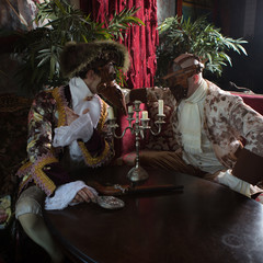 Actors in Steam punk masks and antique costumes indoor.