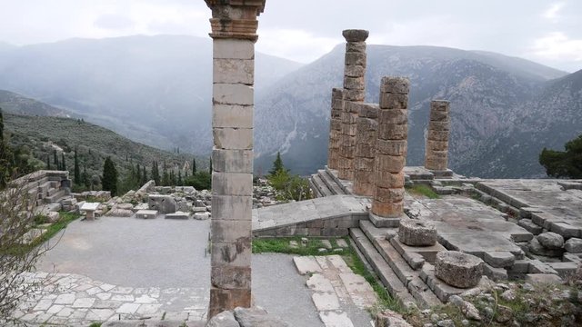 Delphi, Grece, Europe - dicember 30 2019: turists visit the ruins of the ancient temple of Apollo, archaeological site of Delphi along the slope of Mount Parnassus, UNESCO World Heritage, Greece.