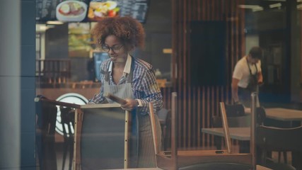 Cheerful small business owner preparing restaurant for opening in morning