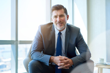 Positive business CEO smiling warmly at the camera