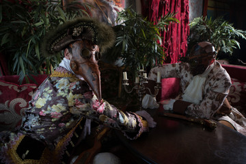 Actors in Steam punk masks and antique costumes indoor.