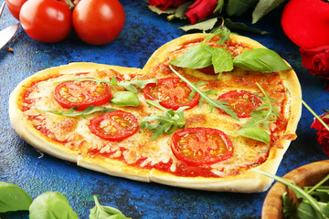 pizza Heart shaped margherita with tomatoes and mozzarella vegetarian. Food concept of romantic love pizza for Valentines Day.
