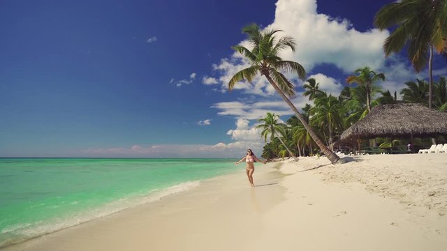 Happy woman running on exotic beach. Tropical island on Caribbean sea. Dominican Republic