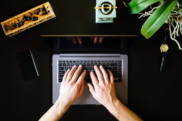 man hands working on modern laptop. Office desktop on black background. freelancer concept. Work at home. business teamwork
