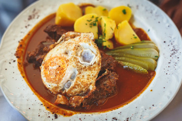 Traditional hungarian and austrian dish - beef goulash with garnish egg noodles, mashed potatoes in Vienna, Austria