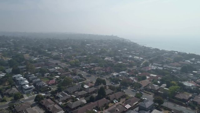 Forward flight over residential area in Melbourne covere in smoke haze resulting from bush fires