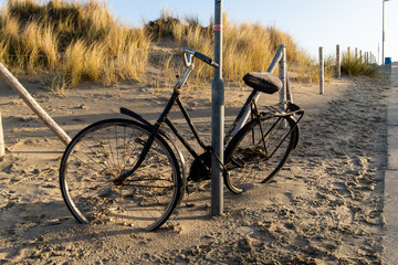 Bicycle left behind on the beach in Holland in the dunes