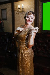 a woman in a gold dress in the image of 20s, looking at the camera and smiling, weighs a lame...