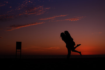 Fototapeta na wymiar Los Cabos, Mexico- 2019 Love is an intense feeling of deep affection Illustrative Romantic portrait of the silhouette of a couple on a beautiful sunset at the beach. Love concept