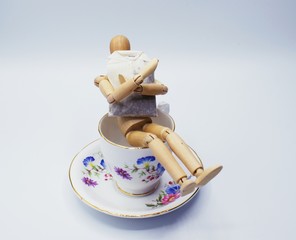 Drawing Mannequin sitting in flora china teacup while holding a tea bag