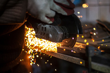Metal cutting. Grinding steel. Work as a grinder. Sparks from friction. Men's work. Creating a...