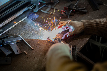 Metal welding. Sparks from electric heating. Work in the workshop. Creation of reliable fastening of materials. Fabrication of iron. The work of the master of metal.