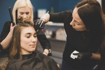 Eyebrow dyeing. The master paints eyebrows with henna to a beautiful girl, paints with a brush in...