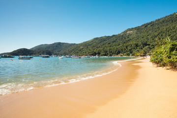 Abraaozinho beach with taxi boat and blue waters in Abraao, on the tropical Ilha Grande, Angra dos Reis, in the south of Rio de Janeiro Brazil