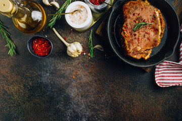 Marinated raw pork steaks on iron. Ready to cook. Dark photo. Top view.