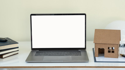 Notebook computers with a white screen on a home-style desk and a tiger leather notebook