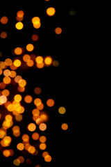 Black background with bright warm bokeh lights. Holiday, Christmas and New Year background. Ideal to layer with any design. Horizontal