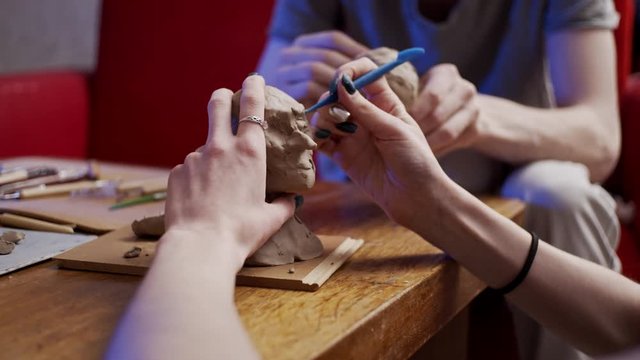 Two young artists sculpting using Plasticine (non-drying clay)