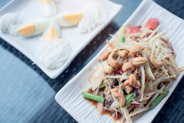 Spicy papaya salad with rice noodles and egg boiled, famous Thai food