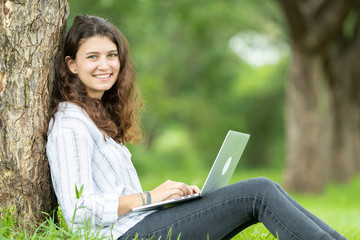 Picture of happy young woman so cute be smile working with her laptop in the park outdoors 