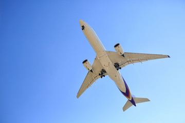 Airplane flying on blue sky. Seen from below.
