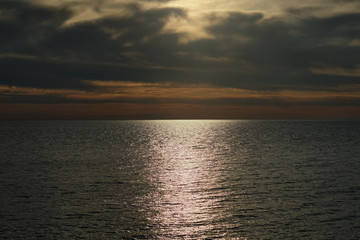Golden path on a surface of water during sunset.