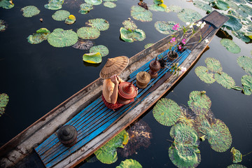 Burmese Intha woman in a rowing boat in the morning at In Dain Khone village, on Inle Lake, Myanmar. - obrazy, fototapety, plakaty