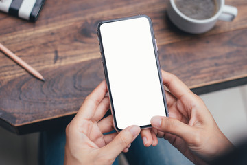 Mockup image blank white screen cell phone.man hand holding texting using mobile on desk at coffee shop.background empty space for advertise text.people contact marketing business,technology 