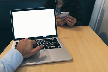 Fototapeta premium mockup image blank screen computer with white background for advertising text,hand man using laptop contact business search information on desk at coffee shop.marketing and creative design