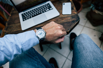 looking at luxury watch on hand check the time at workplace.concept for managing time organization working,punctuality,appointment.fashionable wearing stylish