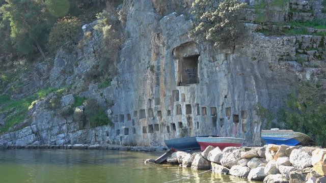 Candir village, Mugla, Turkey - 18th of December 2019: 4K Grave rock with hollows for ash
