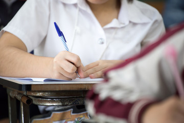 high school,university student study.hands holding pencil writing paper answer sheet.sitting lecture chair taking final exam attending in examination classroom.concept scholarship for education abroad