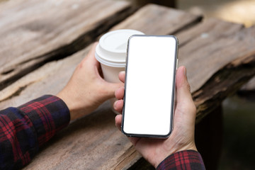 Mockup image blank white screen cell phone.man hand holding texting using mobile on desk at coffee shop.background empty space for advertise text.people contact marketing business,technology 