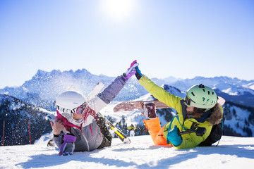 two girls with ski and snowboard having fun on snow - obrazy, fototapety, plakaty