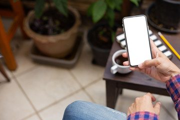 Mockup image blank white screen cell phone.man hand holding texting using mobile on desk at coffee shop.background empty space for advertise text.people contact marketing business,technology 