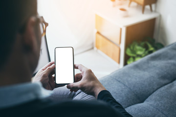 Mockup image blank white screen cell phone.man hand holding texting using mobile on desk at coffee shop.background empty space for advertise text.people contact marketing business,technology 