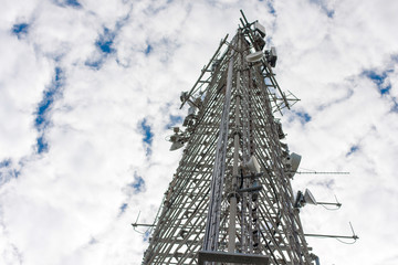 Metal tower with different transmitting and receiving signal equipment in perspective against the...