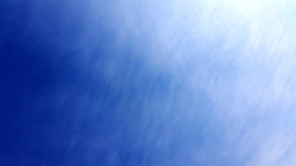 Clear blue sky  photograph shot with interweave clouds. Clean cloudscape space with just a wisp cloud to be used like a backdrop in your work  space. Royalty free stock images.