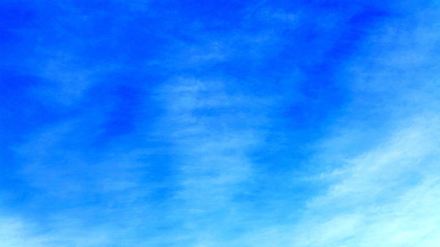 Clear blue sky abstract shot with wisp clouds. Plane sky space with just a smoot cloud for  use as a backdrop in your designing  area. Royalty free stock picture.