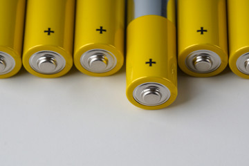 Close up on alkaline battery size AA. Several batteries in row over white background.