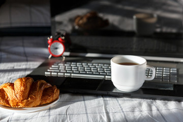 Close up of pencils, notebook, laptop and cup of coffee in the bed. Workspace for freelance, lifestyle. Deadline time concept. Flat lay	