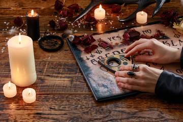 Mystic ritual with Devil's board and candles. The girl calls spirits.The mystical atmosphere of...