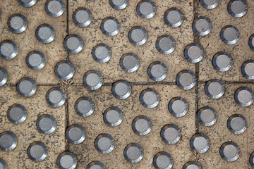 Closeup view of metal floor studs that help the visually impaired.