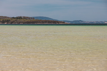 view of Dunalley Beach in Tasmania, Australia with sandbanks and shallow pristine water
