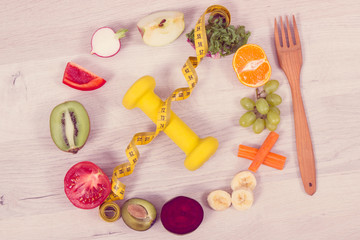 Fototapeta premium Fuits and vegetables, dumbbell and tape measure, concept of nutritious food, healthy lifestyles and slimming