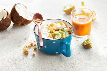 Probiotic food concept. Bowl of homemade coconut yogurt with granola and fresh fruits on light background. Healthy vegan food. Tasty and healthy breakfast