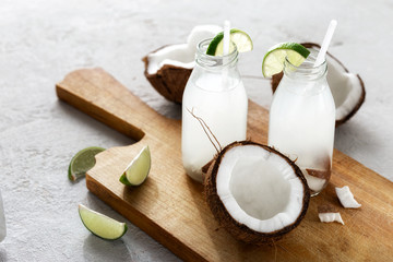 Coconut water in bottles on light background. Healthy veggie drink