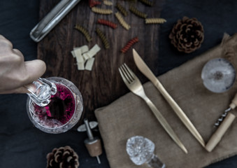 Flat lay composition with pitcher and glasses of red wine and corkscrew on wooden background : traditional winemaking and wine tasting concept.